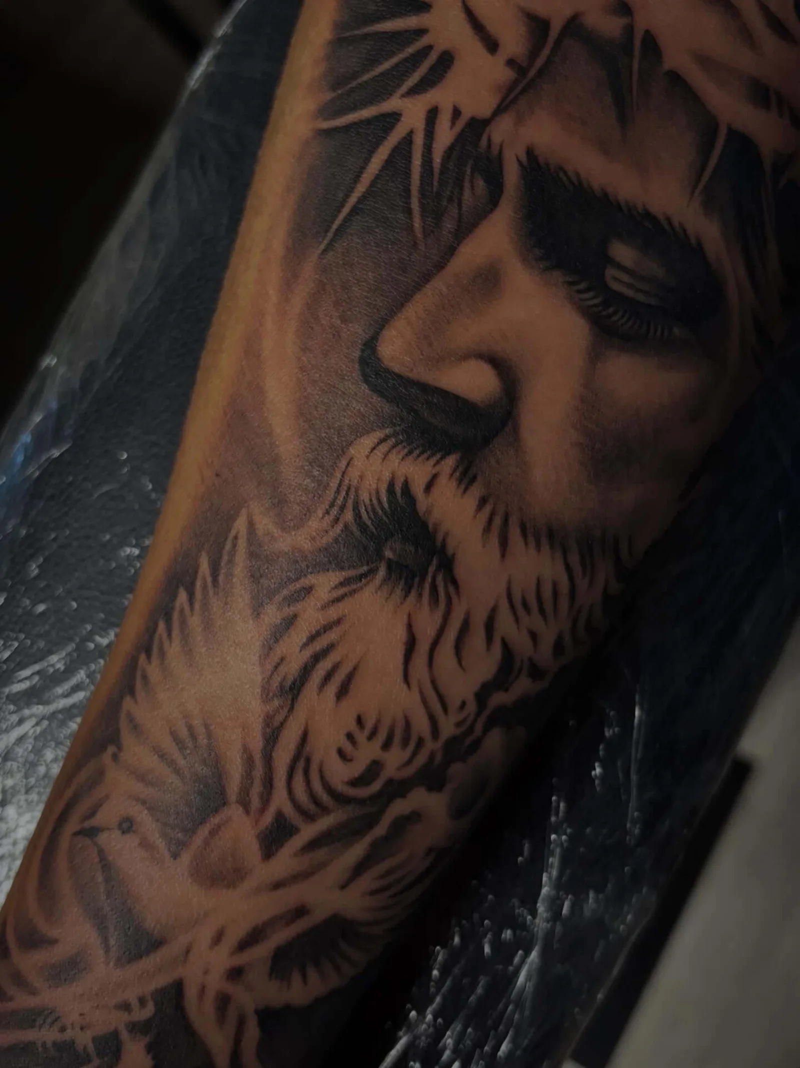Black and grey realism forearm portrait of Jesus with crown of thorns by Creative Tat at Shadow Studio Charlotte