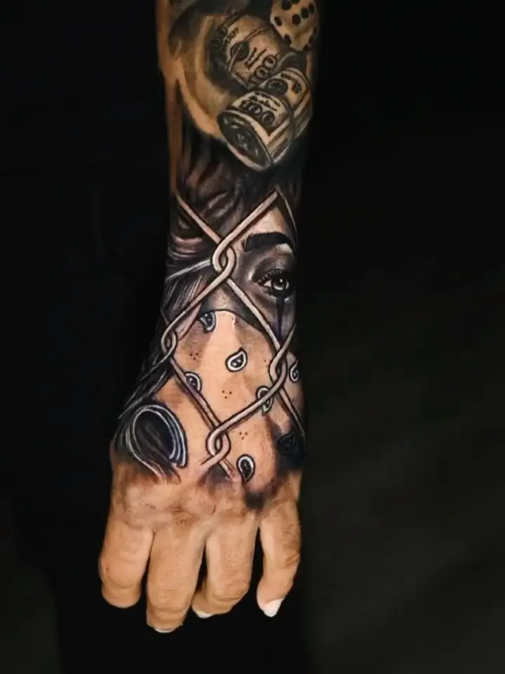 Black and grey hand and lower-forearm sleeve of a veiled face behind iron bars by Fresiato at Shadow Studio Charlotte