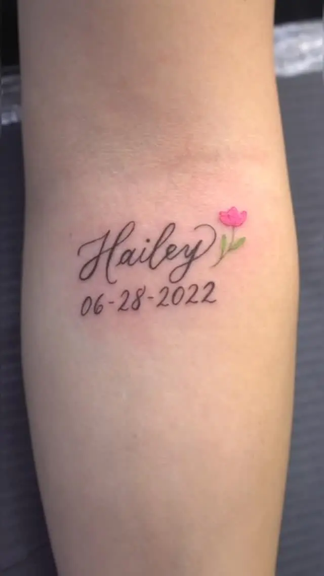 Fine line memorial tattoo with the name "Hailey" and a pink tulip by Gynmo at Shadow Studio Charlotte